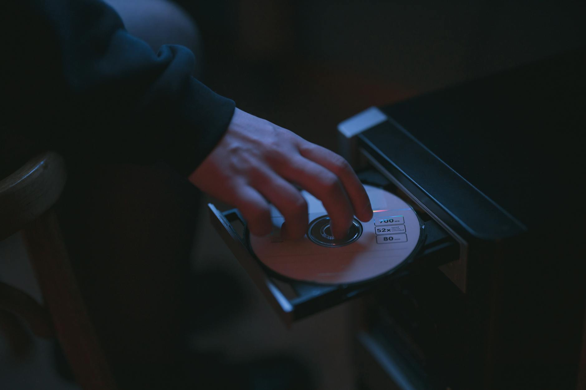 person putting a cd in a computer