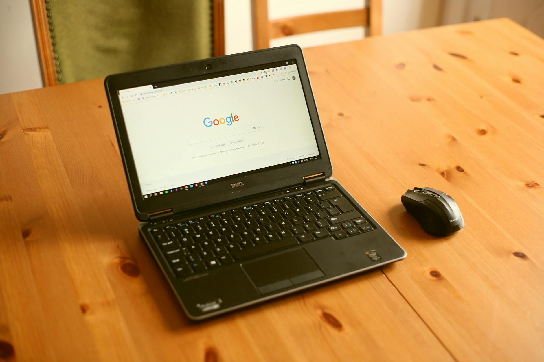 black laptop computer and wireless mouse on table