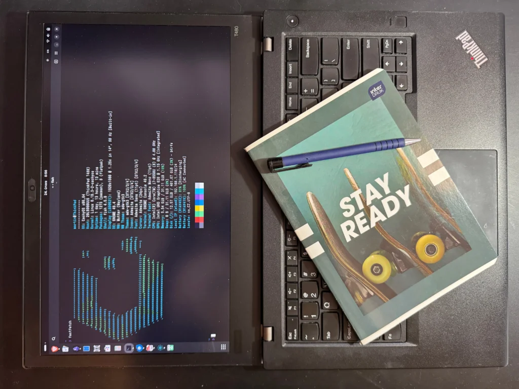 ThinkPad T480 with notebook and pen. Fastfetch on its display.
